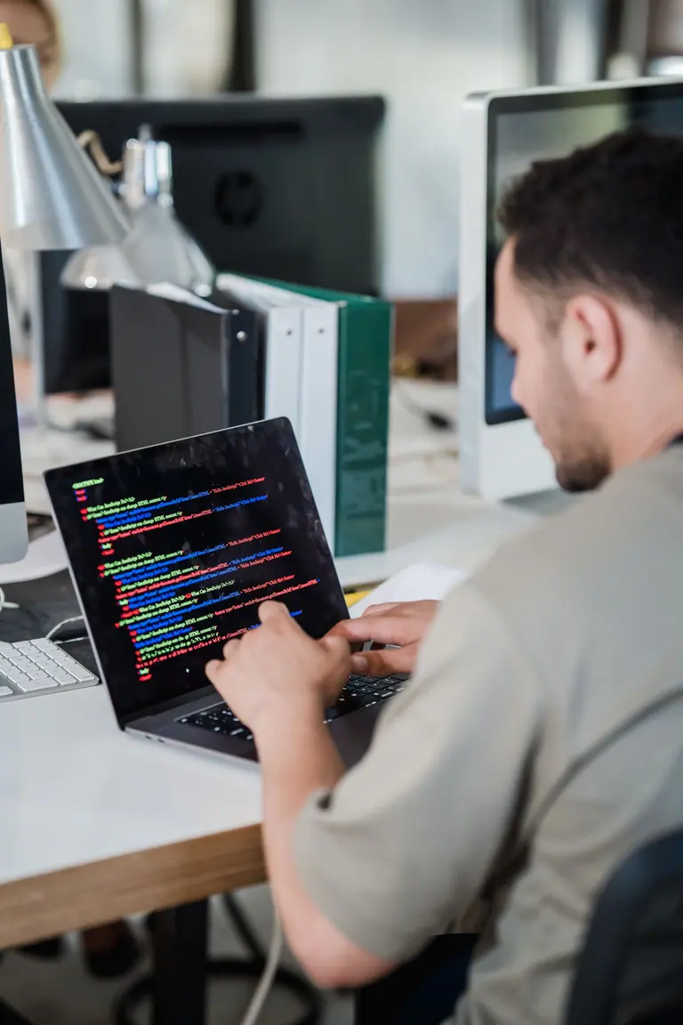 Developer reviewing website code on a laptop in an office